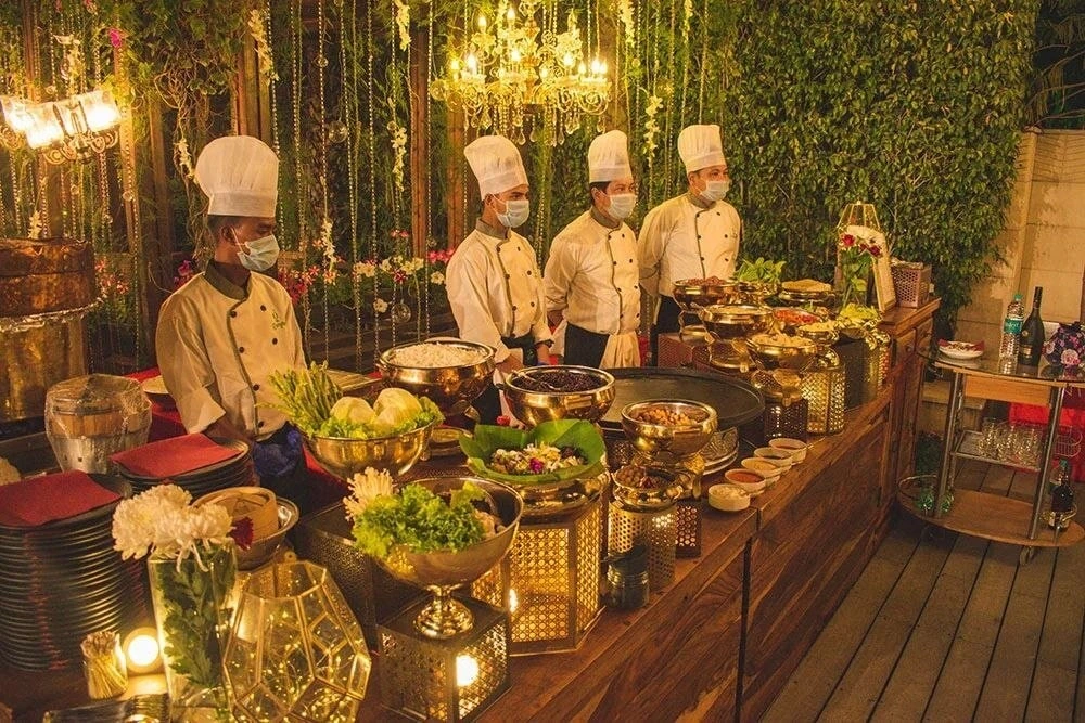Chefs preparing food in a warmly lit celebration setting